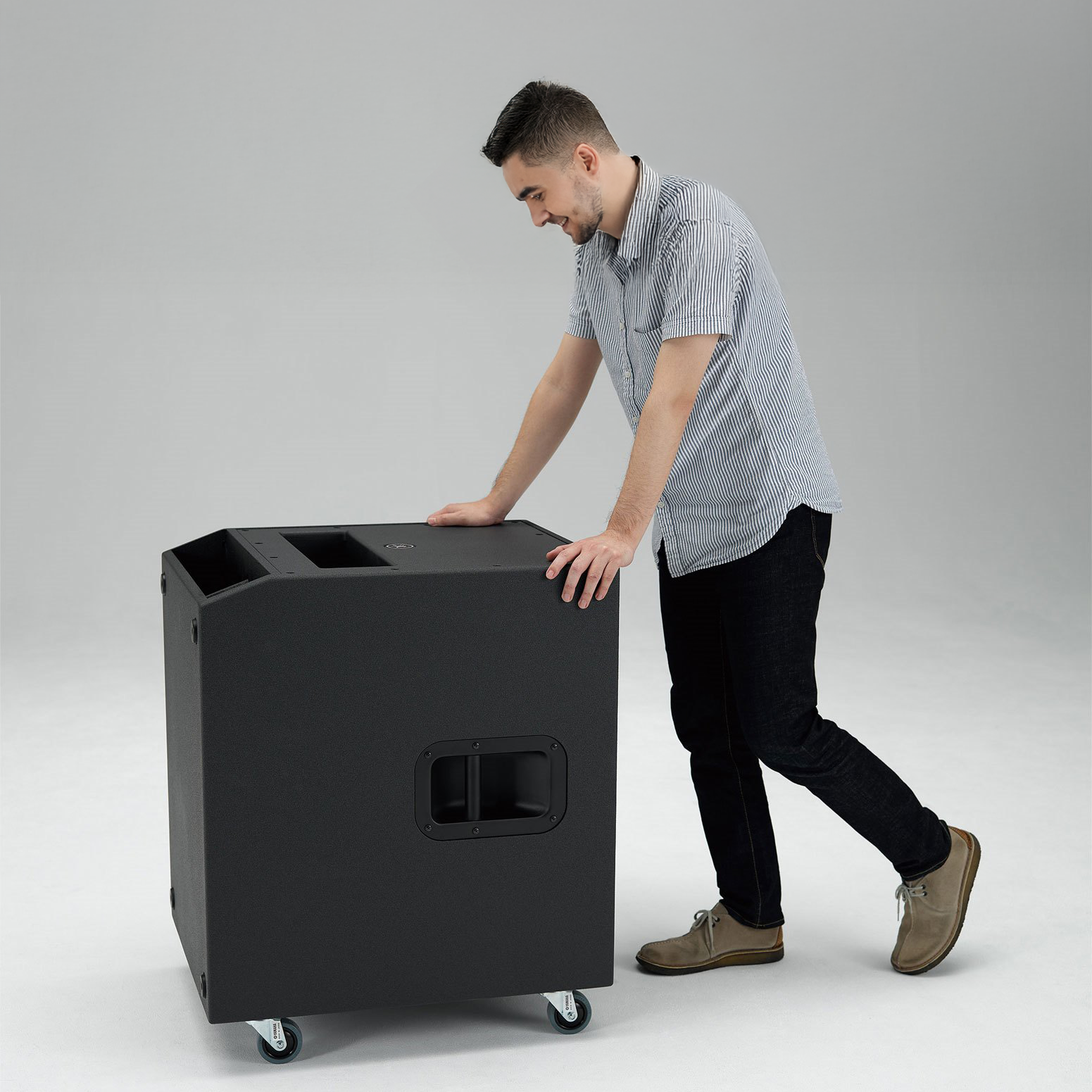 Mann schiebt Yamaha Subwoofer mit rollen